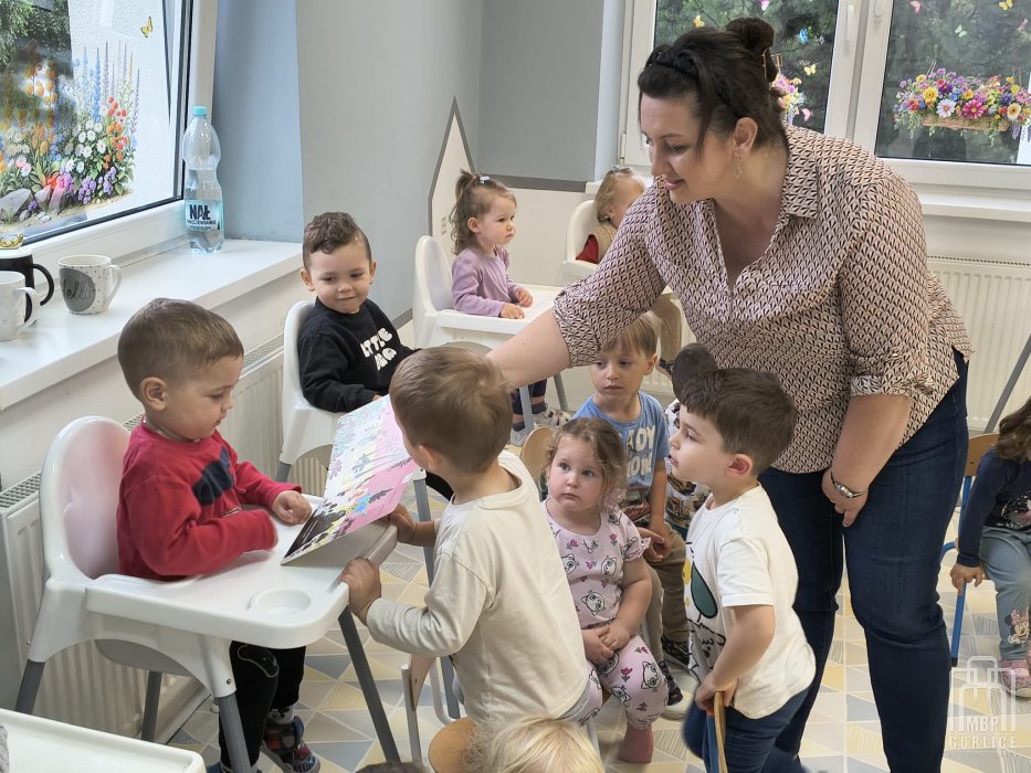 Biblioteka Gorlice, Cała Polska czyta dzieciom bibliotekarka prezentuje dzieciom ilustracje z książki